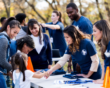 volunteers shaking hand with child