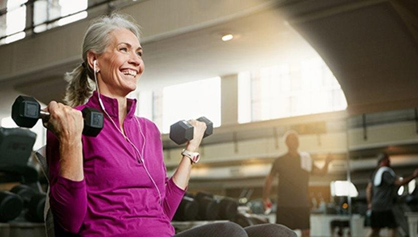 smiley woman lifting weights