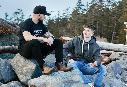 Two young CAF Members chat on rocky shoreline