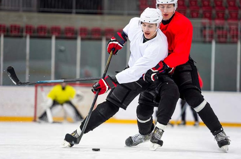 Two CAF Members chase the puck in Arena