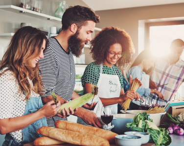  Adults preparing a meal together in a kitchen.