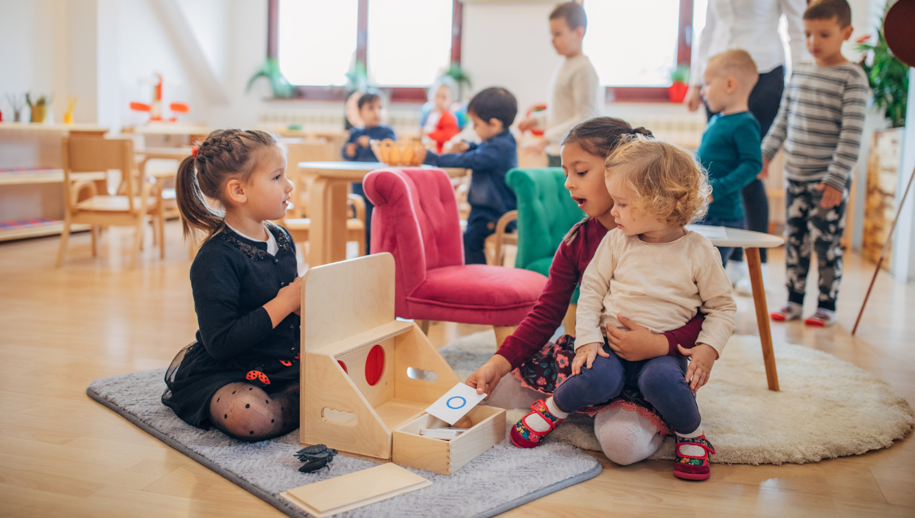 Children playing with toys in a bright classroom.