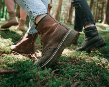 Close-up of boots walking on a mossy forest floor.