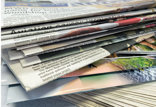A large stack of issues of the Aurora Newspaper.