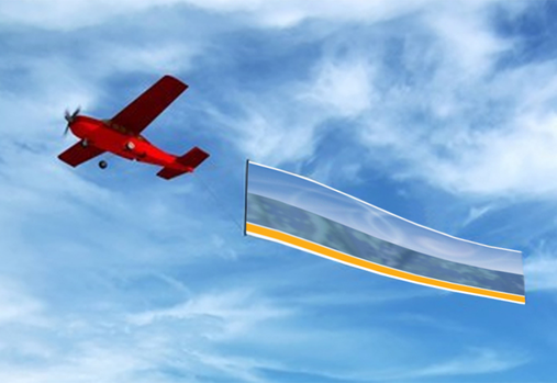 A red airplane in the sky flying an Aurora Newspaper banner.