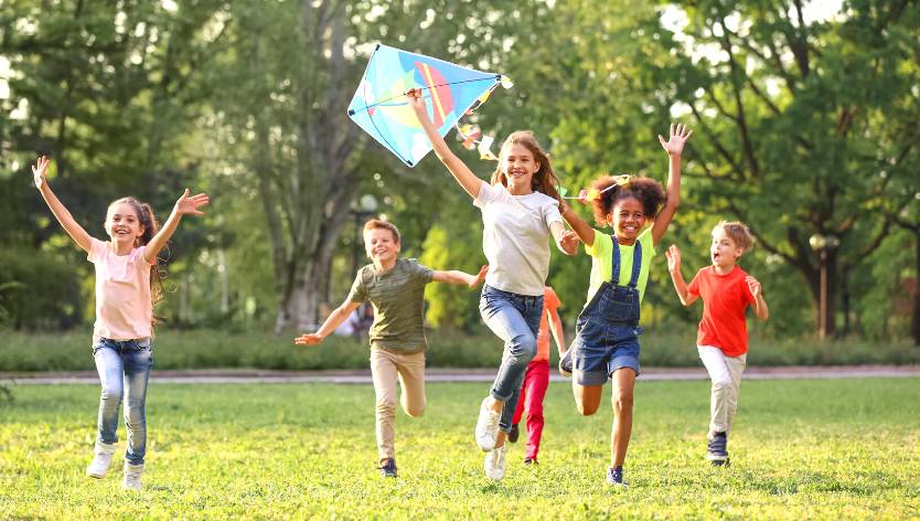 kids running and playing with a kite