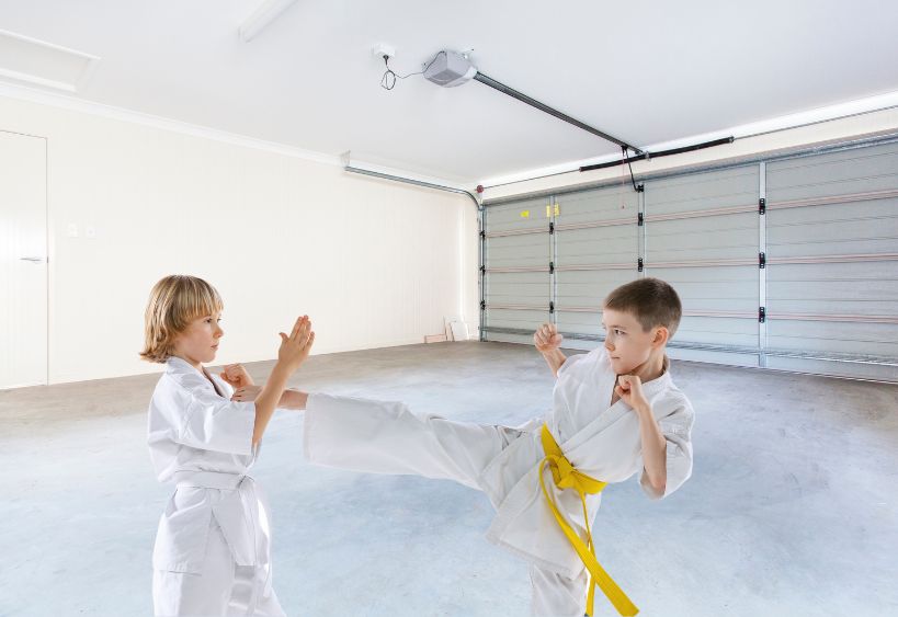 Dynamic portrait of two little boys, taekwondo athletes wearing doboks training together