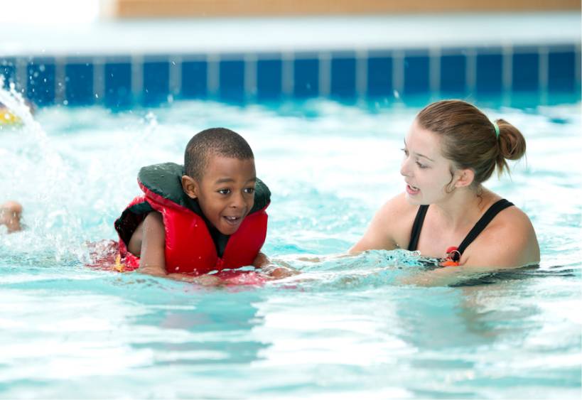 A child and an instructor in a swimming lesson