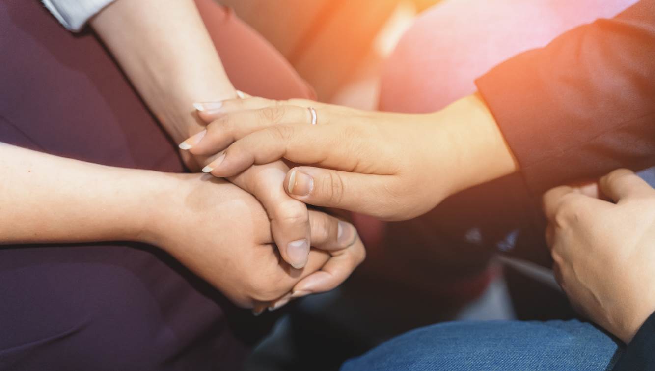 People holding hands in a gesture of support