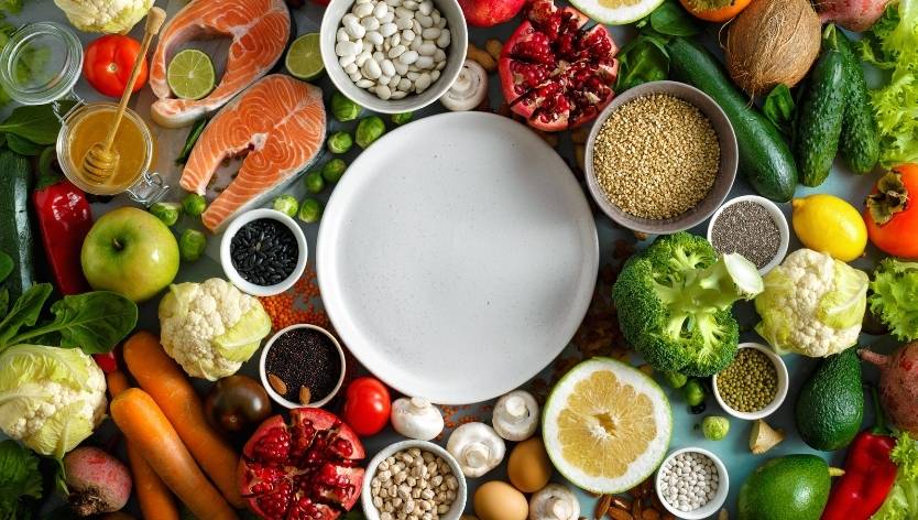 Empty plate surrounded by various foods