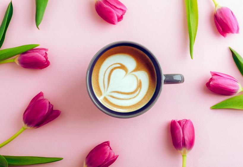 Cup of coffee surrounded by tulips