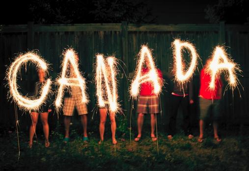 Group of friends holding sparklers that say Canada