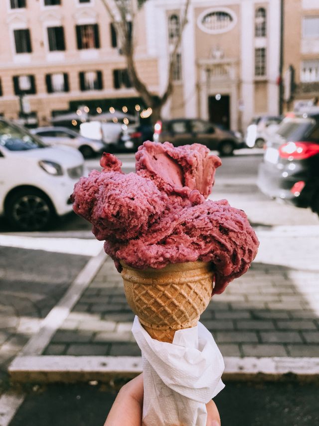 Close-up of a pink gelato cone held outdoors