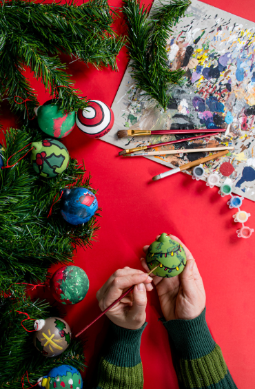 Someone painting a Christmas ornament