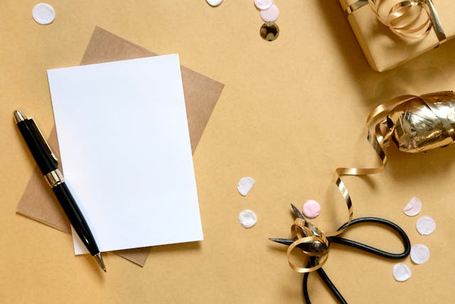 blank card with brown envelope, pen, scissors and gold embellishments