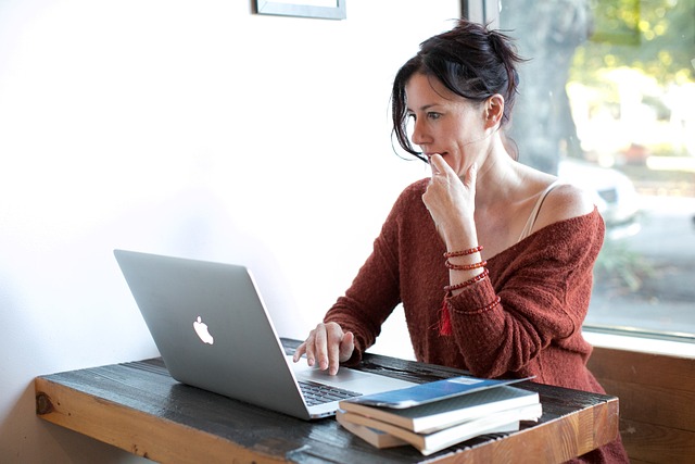 woman sitting at a desk looking at laptop
