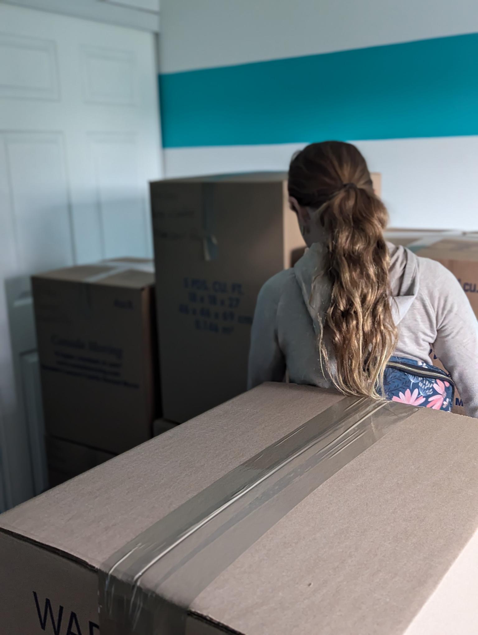girl standing amid boxes
