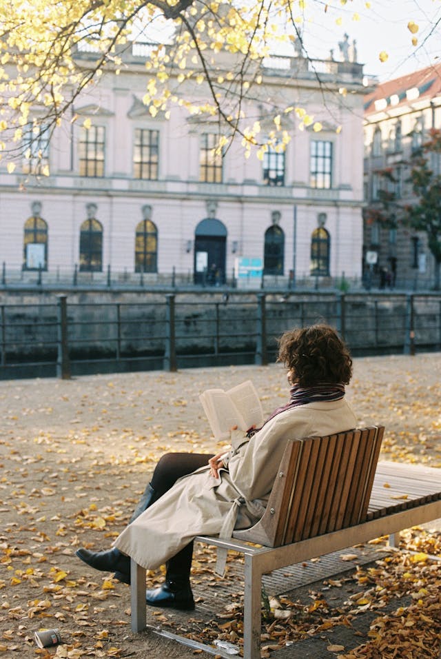 Woman Relaxing on a Park Bench Reading a Book