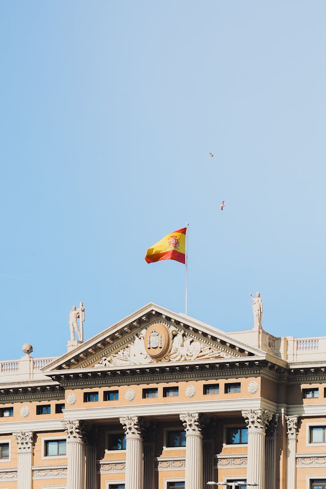 Spanish Flag Waving Above Historic Barcelona Building
