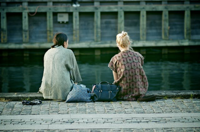 Back View of Two Women Sitting on the Waterfront in Copenhagen, Denmark