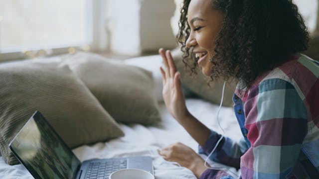Smiling Woman Video Calling on Laptop