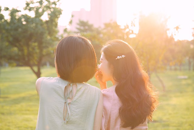 Woman Whispering in Another Woman's Ear