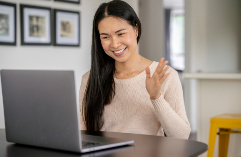 Woman waving at laptop