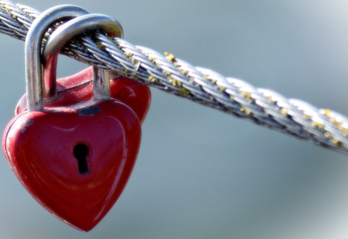2 heart shaped padlocks, locked on a cable