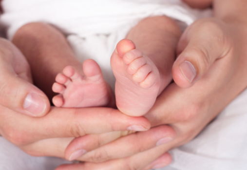 baby feet held in adult hands