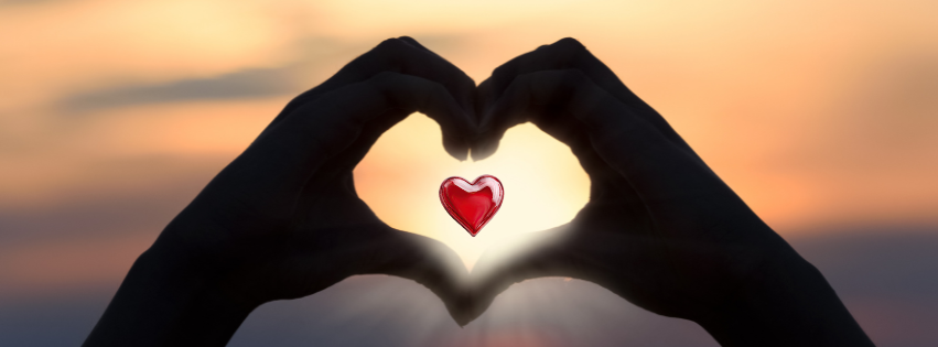 Two hands making the 'heart' shape with a heart in the middle and a sunset