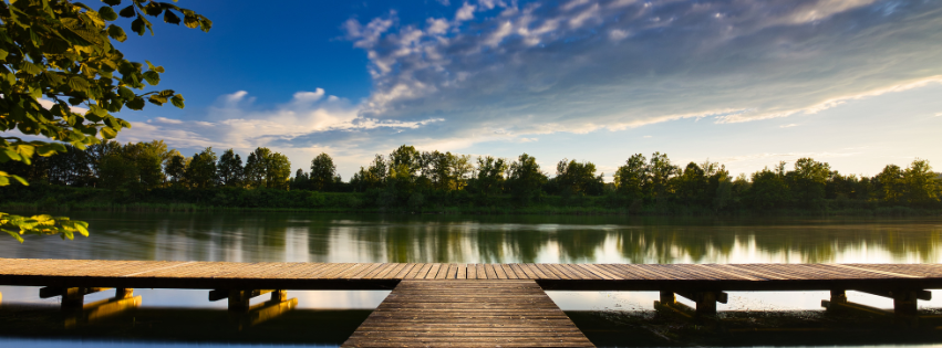 picture of a dock leading to a lake at sunrise