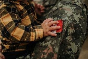 A soldier holding a small child.