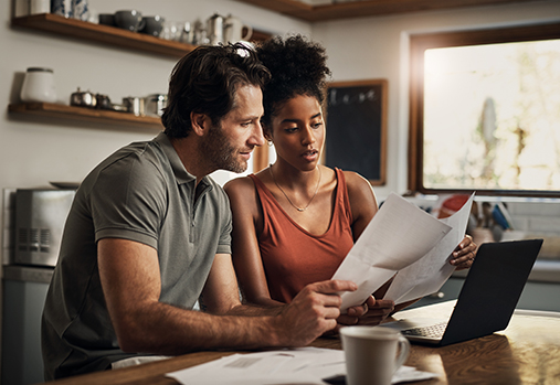 couple at kitchen table looking at paperwork