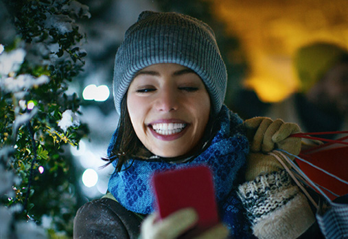 woman carrying packages, looking at cell phone