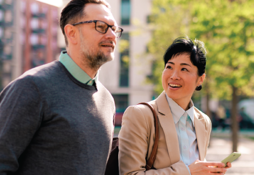 two people walking looking at mobile device