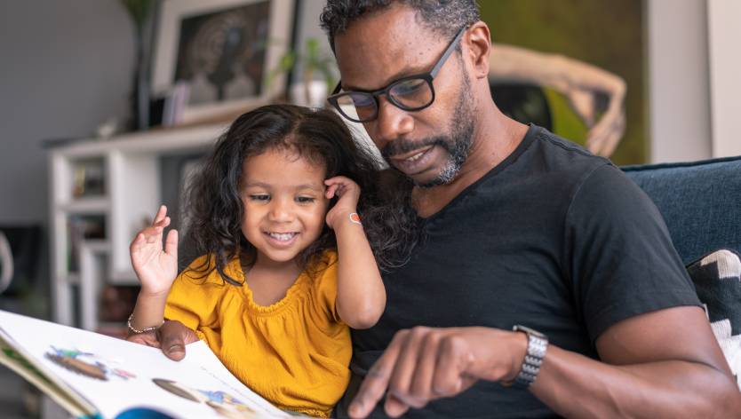 father and child looking at a book