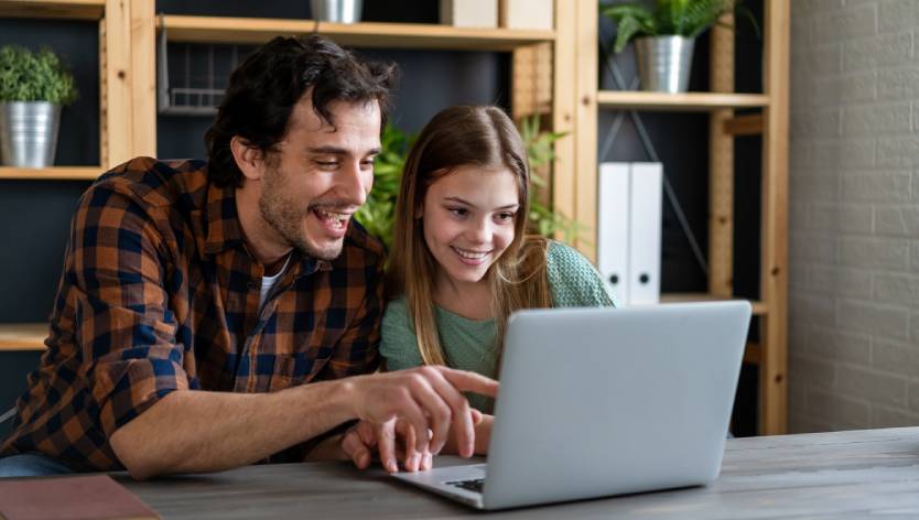 Father and daughter looking at laptop