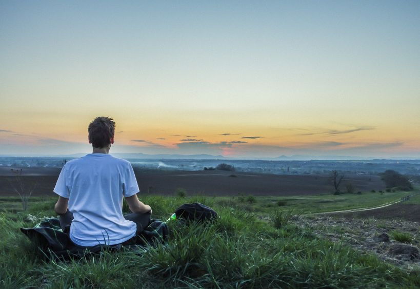 person meditating in nature