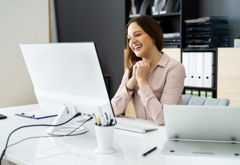 woman smiling and looking at a laptop screen