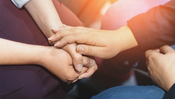 People holding hands in a gesture of support