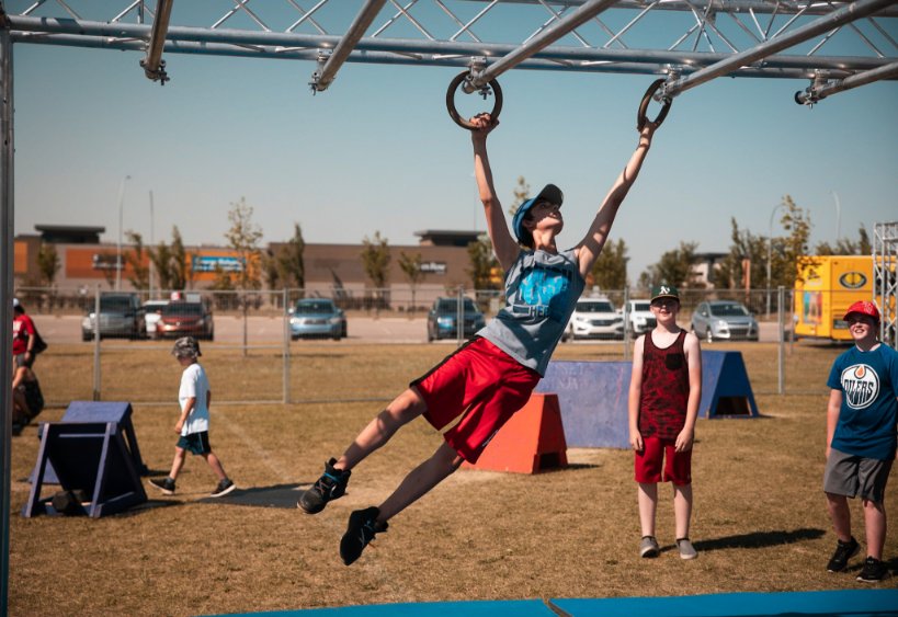 A child swinging on rings on a Fitset Ninja.